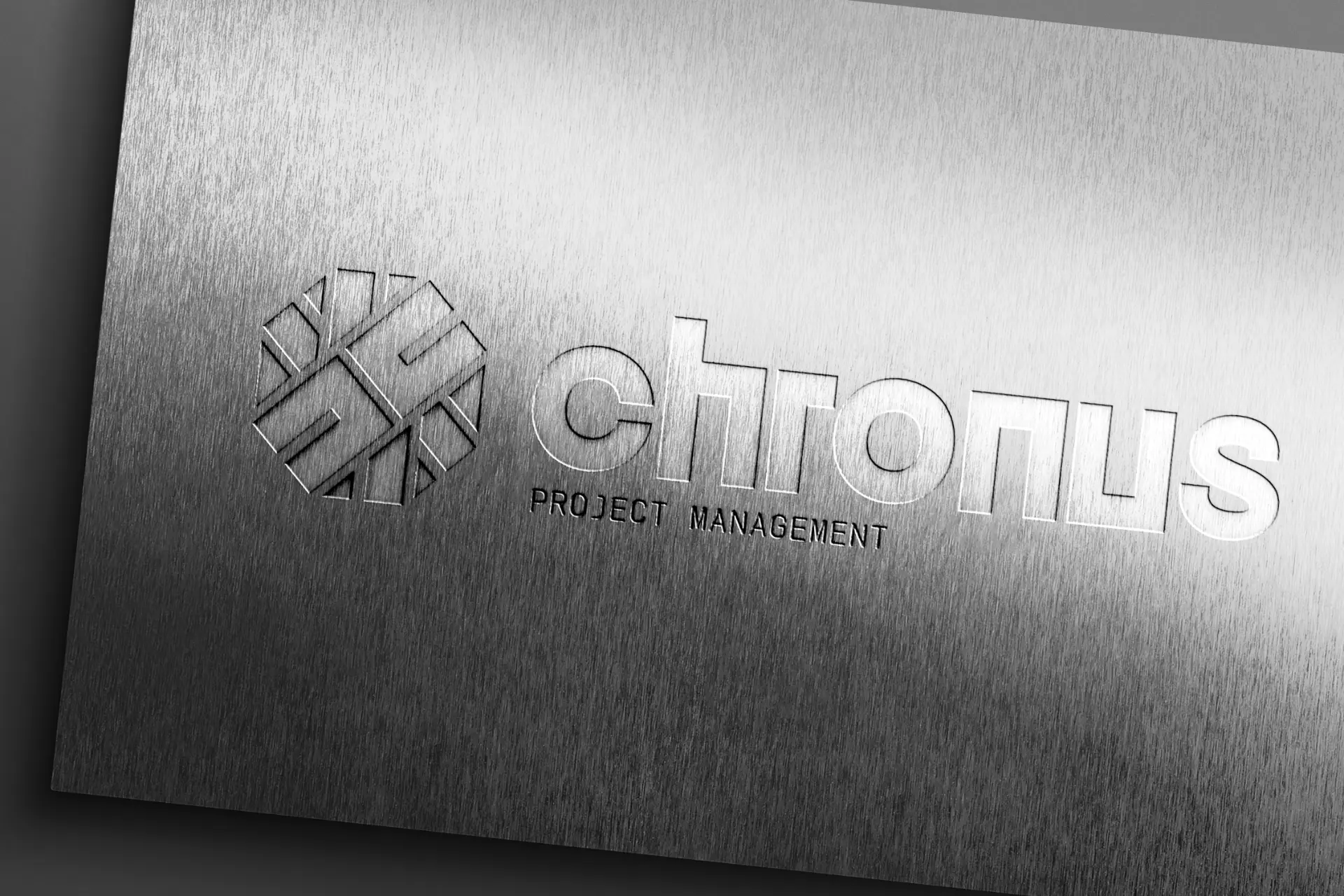 Logotipo Chronus Project Management gravado em placa de aço escovado.